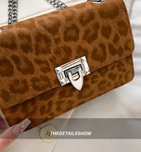 Detail der Schultertasche mit Leopardenmuster, Metallkettenriemen und silberner Schnalle