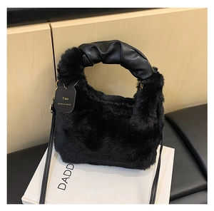 Detailansicht der schwarzen Plüschtasche mit geriffeltem Kunstledergriff und Logo-Anhänger
