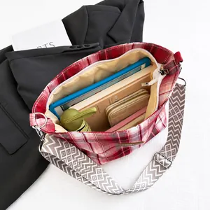 Vue intérieure montrant la grande capacité du sac cabas à carreaux rouges avec sangle