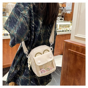 Detalle del bolso ita de lona crema con ventana transparente, orejas y pines lindos