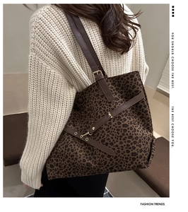Détail du sac cabas léopard avec bandoulière en cuir marron et boucle en métal réglable