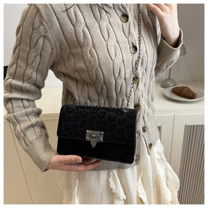 Detail der schwarzen Wildledertasche mit Leopardenmuster, Silberkette und Drehverschluss