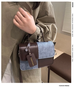 Close-up of contrast crossbody bag with tweed texture and brown faux leather handle