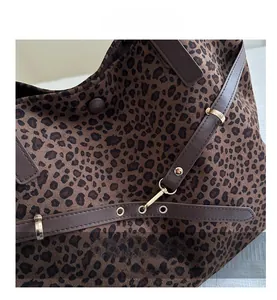 Gros plan sur la texture léopard en daim avec boucle dorée et détails de bandoulière en cuir