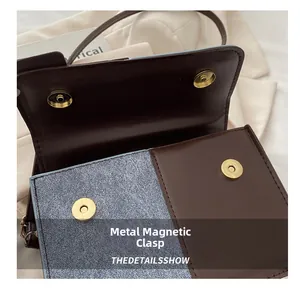 Detail of golden magnetic clasp on vintage contrast-color crossbody bag in brown and blue