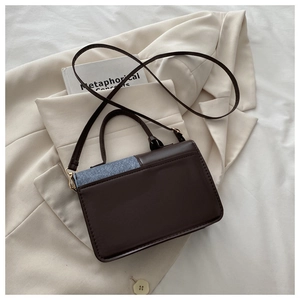 Detailed overhead view of a contrast-color square crossbody bag with textured PU leather