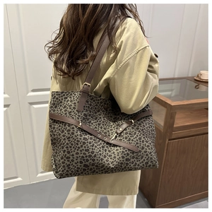 Gros plan détaillé du sac cabas léopard avec lanières en cuir marron et boucle décorative
