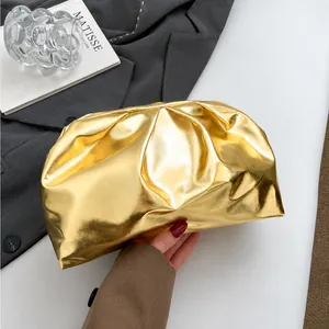 Detail view of golden metallic pleated pouch clutch with premium soft cloud texture