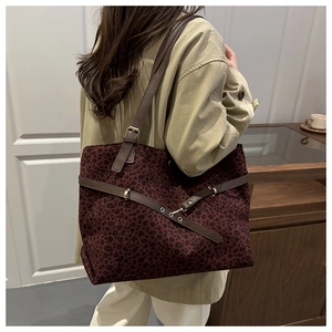 Détail du cabas léopard bordeaux avec bandoulières en cuir marron et boucle à œillets