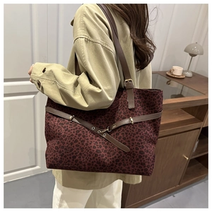 Détail du cabas léopard avec anses en cuir marron et boucle décorative en métal