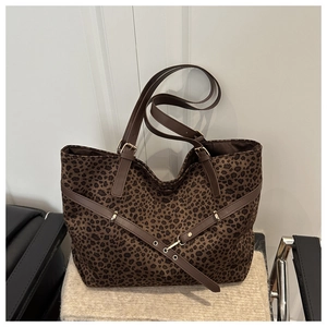 Détail du sac cabas en daim léopard avec lanières en cuir marron et boucle réglable