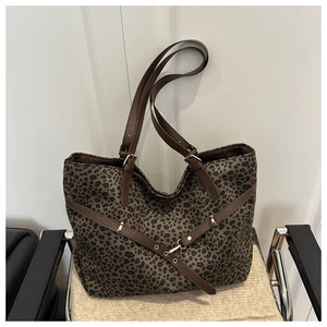Détail du cabas léopard avec lanières en cuir marron et boucles dorées décoratives
