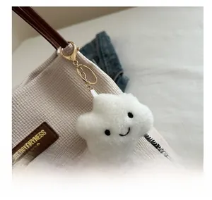 Détail d'un charm nuage en peluche blanche brodée sur un sac en velours côtelé