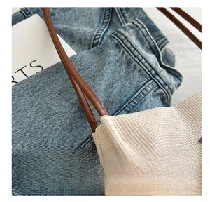 Gros plan sur la texture d'écaille du sac blanc cassé avec bandoulière en cuir brun