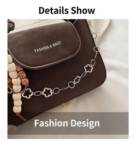 Détail du sac bandoulière en cuir marron foncé avec chaîne fleurie et charm en perles