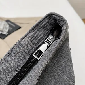 Vista detallada de la cremallera metálica en este bolso de pana gris para mujer