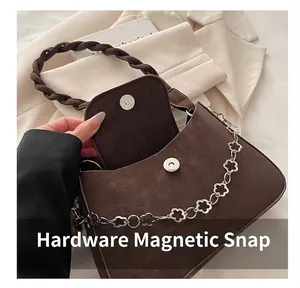 Détails du sac marron avec chaîne en métal à fleurs argentées et fermeture à bouton magnétique