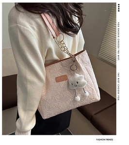 Détail du sac cabas rose clair avec tissu texturé et bandoulière chaîne dorée