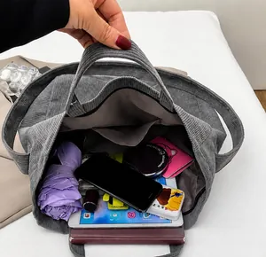 Detalle del bolso tote grande de pana que muestra el interior espacioso con varios objetos