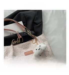 Détail du cabas rose à texture froncée avec chaîne dorée et breloque nuage en peluche