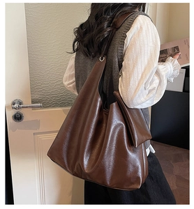 Détail du sac cabas marron café montrant le cuir synthétique brillant et texturé