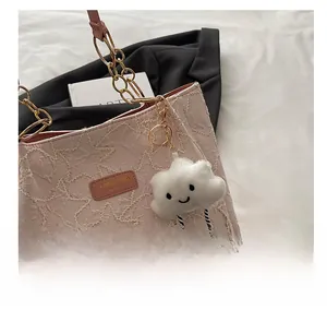 Détail du sac cabas rose avec surpiqûres étoiles, chaîne dorée et gri-gri nuage