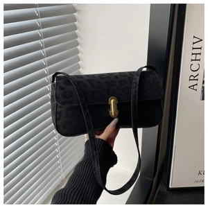 Detailansicht der schwarzen Handtasche mit Leopardenmuster und goldenem Drehverschluss