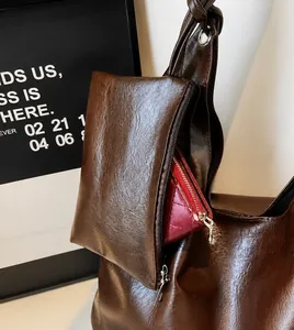 Détail d'un sac cabas marron foncé avec une petite pochette zippée assortie amovible