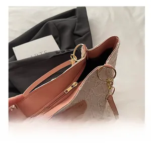 Détail du zip doré et doublure rose à l'intérieur du sac fourre-tout tissé beige