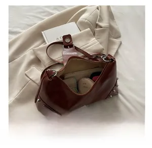 Interior storage view of brown retro rivet tote bag showing space for phone and wallet