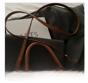 Dettaglio della tracolla in pelle regolabile e borsa a tracolla vintage testurizzata con fibbie