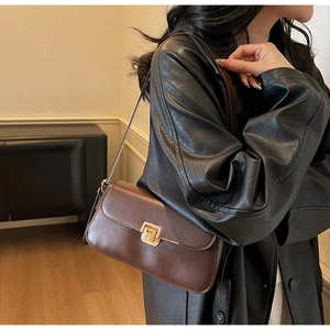 Détail du sac baguette en cuir marron avec fermoir à poussoir rectangulaire en métal doré