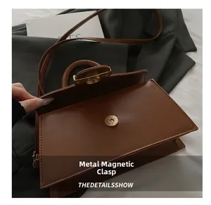 Dettaglio della fibbia magnetica di una borsa a tracolla in pelle marrone retrò
