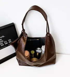 Détail de l'intérieur spacieux du grand sac hobo marron avec tablette et cosmétiques