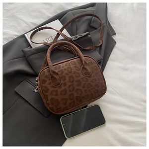 Mini leopard print handbag with silver hardware and shoulder strap shown with phone for scale