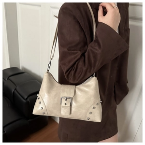 Close-up of beige rivet shoulder bag worn with brown blazer showing Y2K vintage style