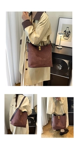 Detail of dark brown suede bucket bag featuring a gold twist lock and adjustable strap