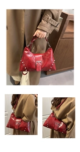 Detail view of red vintage oil wax leather bag with silver rivets and metal buckle strap