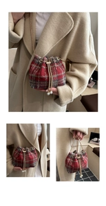 Dettaglio borsa a secchiello in tweed a quadri rossi e grigi con catena dorata e perla