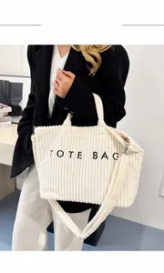 Détail du cabas en velours côtelé blanc cassé montrant la texture et l'inscription TOTE BAG