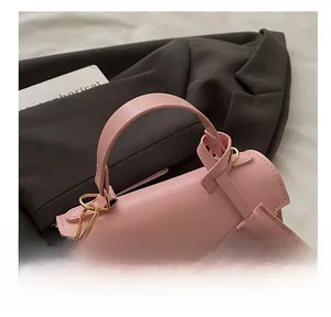 Detailed close-up of pink cherry print handbag with gold lock on brown coat