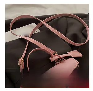 Detail of pink cherry print bag showing golden rotary metal clasp and leather texture