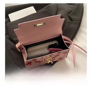 Internal view of pink cherry print bag showing storage for phone and wallet with hardware lock