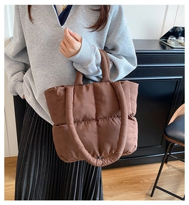 Detalle del bolso acolchado marrón que muestra las costuras cuadradas y textura suave