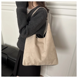 Detail of a beige matte suede tote bag showing soft texture and large capacity
