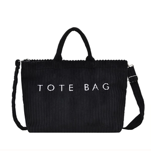 Bolso tote de pana negra con bordado de letras blancas y correa desmontable