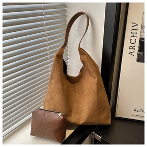 Detail of matte suede tote bag with matching leather pouch in minimalist home setting