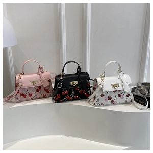 Tre mini borse a tracolla con stampe di ciliegie in rosa, nero e bianco in dettaglio