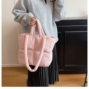 Detalle del bolso acolchado rosa con costuras cuadradas y textura de nailon suave