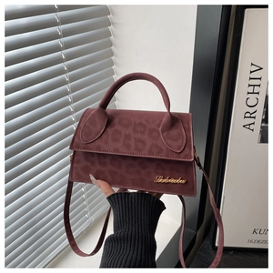 Dettaglio della borsa bordeaux in pelle scamosciata leopardata con logo in metallo
